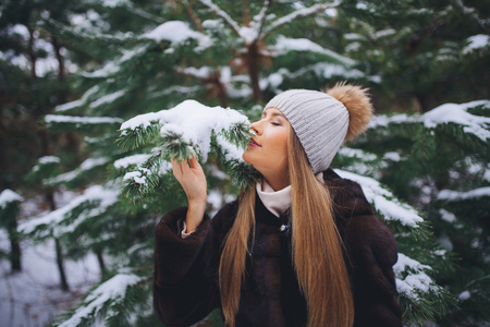 Young model girl walk in the winter forest with snow covered branches.の写真素材