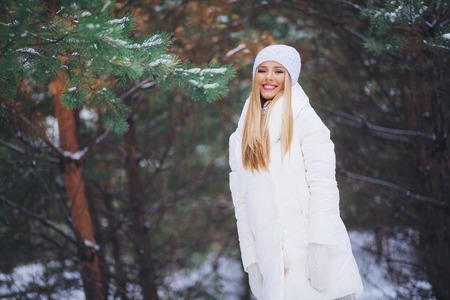 Happy, young europian model with beautiful smile walk in the winter snowy forestの写真素材