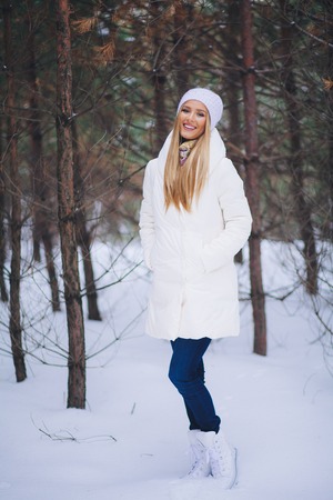 Happy, young europian model with beautiful smile walk in the winter snowy forestの写真素材