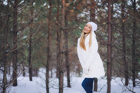Happy, young europian model with beautiful smile walk in the winter snowy forestの写真素材