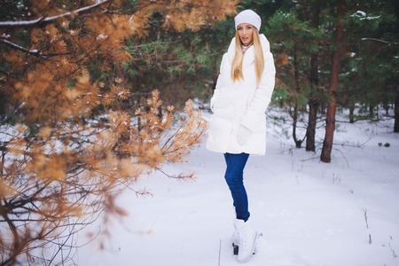 Young model girl walk in the winter forest with snow covered branches.の写真素材