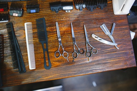 Hairdresser's tools on a wooden brown tableの写真素材