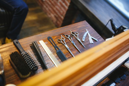 Hairdresser's tools on a wooden brown tableの写真素材