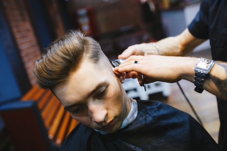 Man at the hairdresser. Portrait of a young white boy while cutting hair in the hair salon