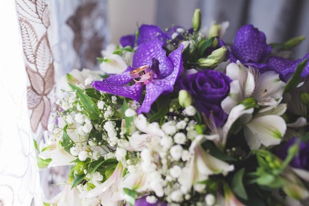 Gold wedding rings on flower bride bouquet.の写真素材