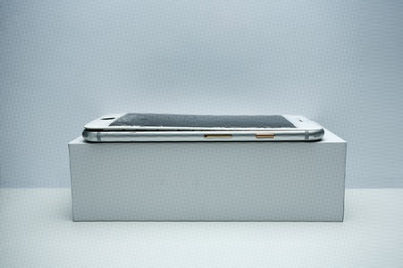 Modern mobile phone with broken screen on white background.の写真素材