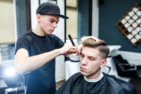 Hairdresser shaving man with a straight razor.