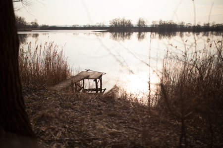 Wooden dock, pier, on a lake in the evening.の写真素材