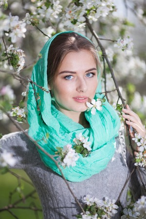 Beautiful Woman Fashion Model with Spring Blossoms Background. Spring Beauty Woman with Apple Tree Flowers.の写真素材