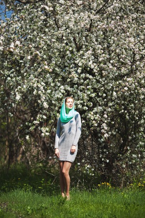 Beautiful Woman Fashion Model with Spring Blossoms Background. Spring Beauty Woman with Apple Tree Flowers.の写真素材