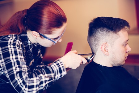 young attractive woman hairdresser make hairstyle for man.