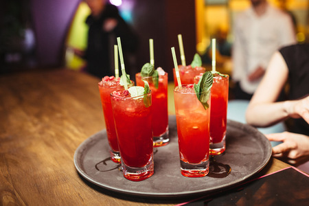 Set of alcoholic red cocktails with mint on the wooden table.の写真素材