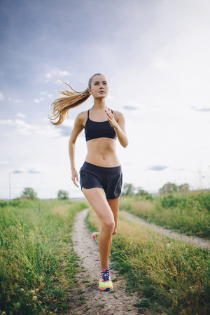 A young girl jogging outdoor.の写真素材