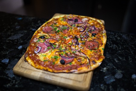 Pizza with salami and vegetables.