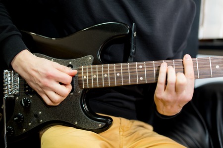 Guy plays guitar close upの写真素材