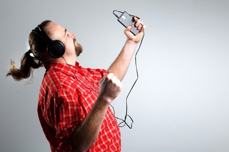 Bearded man in headphones listening to music.の写真素材