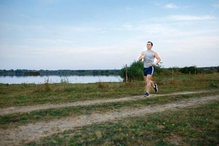 Sport and fitness runner man doing outdoors training for marathon run. Guy doing high intensity...