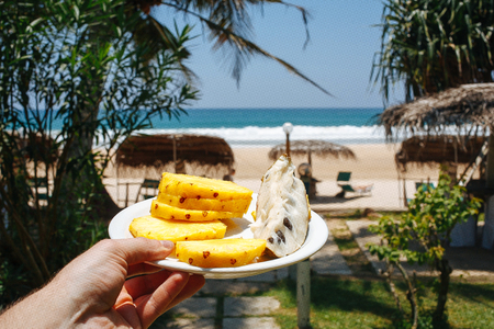 Slice of watermelon in the hand over sea background and beautiful blue sky with the wave and bubble, for summer beach concept.の写真素材