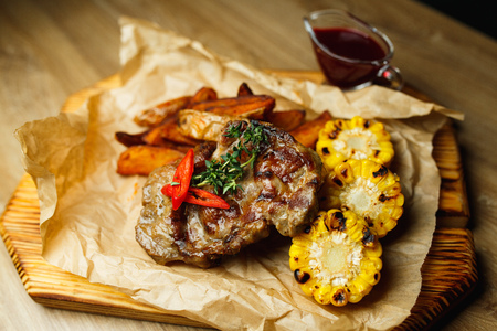 Pork steak with grilled corn and potatoes in creole.の写真素材