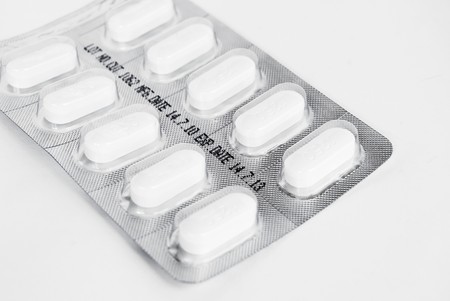 pack of white medicine pills on white backgroundの写真素材