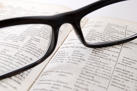 closeup of old dictionary and black glasses with penの写真素材