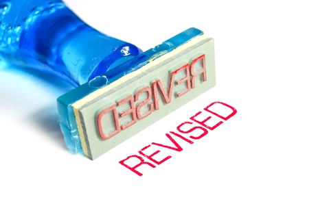 revised letter on blue rubber stamp isolated on white backgroundの写真素材