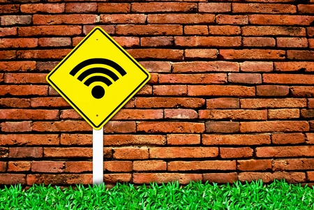 wi-fi internet traffic symbol sign on brick wall background and grass fieldの写真素材