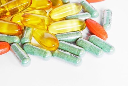 colorful vitamin and medicine pills closeup on white background