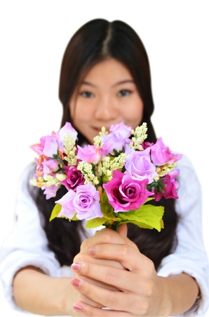 Woman smiling and showing flowers isolated on white backgroundの写真素材