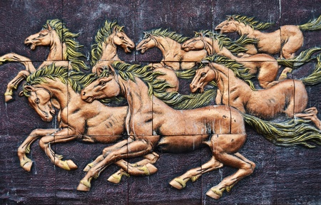 Stone sculpture of horse on wall in Thailandの写真素材