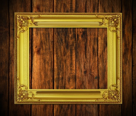Old antique gold frame on wood texture backgroundの写真素材