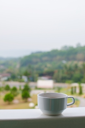 Coffee in a cup on balcony with nature and mountain backgroundの写真素材