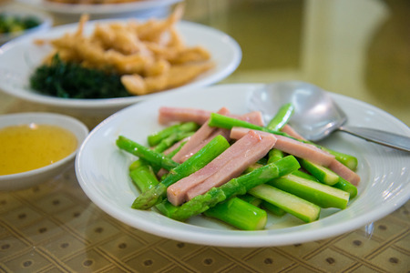 Fried asparagus with ham and oyster sauceの写真素材