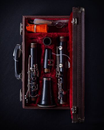 Vintage Wood Body Clarinet in Original Red Velvet-Lined Hard Case overhead shot on dark backgroundの写真素材