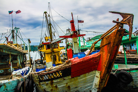 A small colorful fishing boat in a small port - Borneo, Malaysia, Asiaのeditorial素材