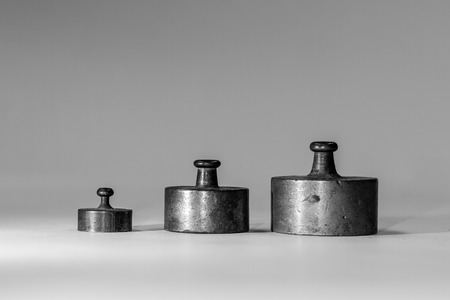 Collection of Thee Small Vintage Iron Calibration Weights on Grey Backgroundの写真素材