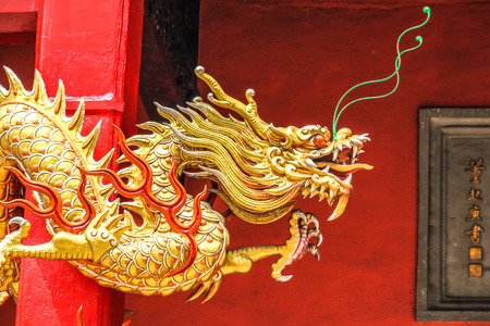 Golden Chinese Dragon with the Red Wall in the Backgroundの写真素材