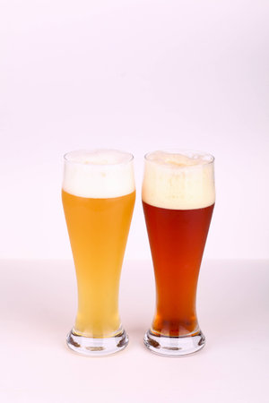 Two glasses of beer over a white backgroundの写真素材