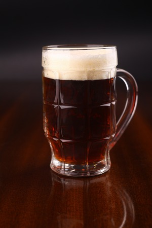 Mug of dark beer over a dark background