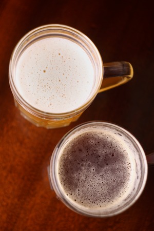 Two mugs of beer on a wooden table
