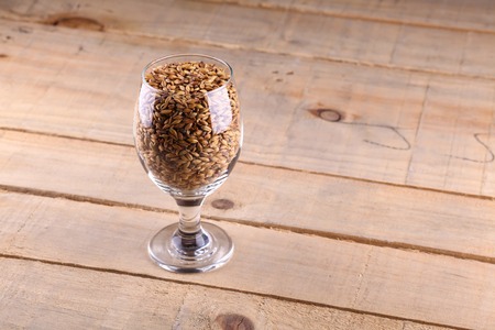 Glass full of barley malt over a wooden backgroundの写真素材