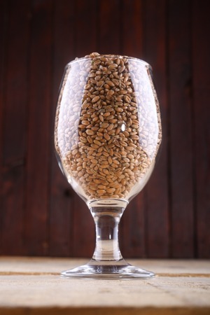 Glass full of light wheat malt over a wooden backgroundの写真素材
