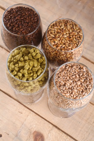 Glasses full of malts and hops over a wooden backgroundの写真素材