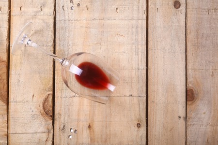 Glass with some red wine on a grunge wooden tableの写真素材
