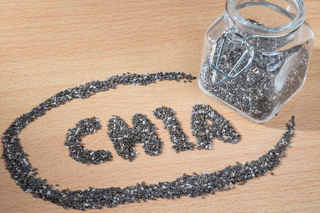 chia word made from chia seeds on wooden plateの写真素材