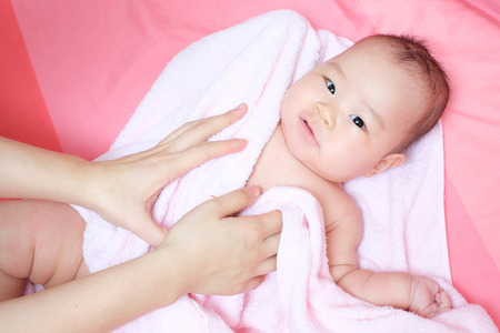 Mom rub her baby to dry whit pink towelの写真素材