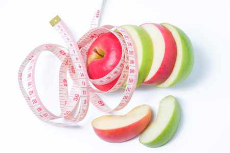 slice red and green apples with waist measure on white backgroundの写真素材