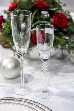 Two wineglasses, christams-tree decoration ball and blurry bunch of roses on the background の写真素材