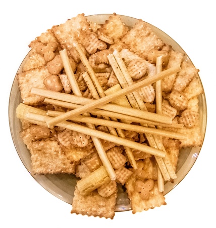 Round plate with cookies, waffles, crackers and sticks isolated on whiteの写真素材