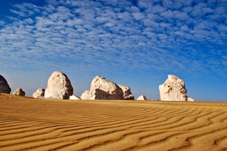 The limestone formation in White Desert and the waves of a golden sandの写真素材